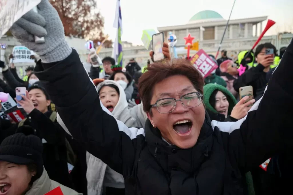 La gente celebra después de que el parlamento surcoreano aprobara una moción de destitución contra Yoon el 14 de diciembre. Kim Hong-Ji/Reuters